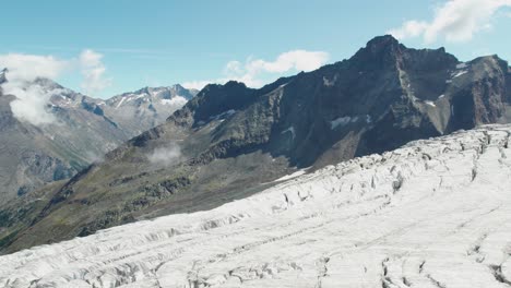 Vuelo-De-Drones-Sobre-Glaciares-De-Hielo-Con-Grietas,-Derretimiento-De-Glaciares-Durante-El-Verano-Debido-Al-Calentamiento-Global,-Sobrevuelo-Aéreo-De-Allalingletscher-Suiza