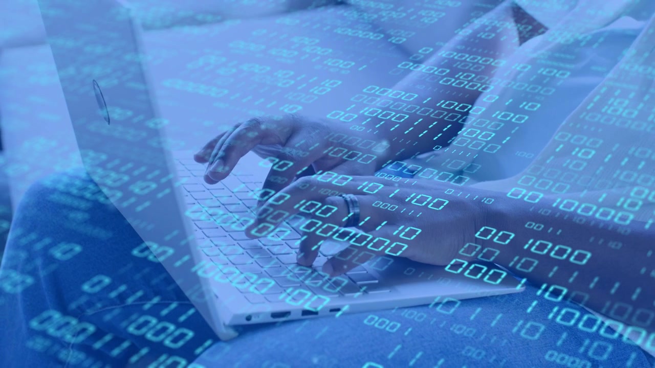 Man typing on lap laptop, initial keystroke initiating drifting blue binary overlay for tech demo