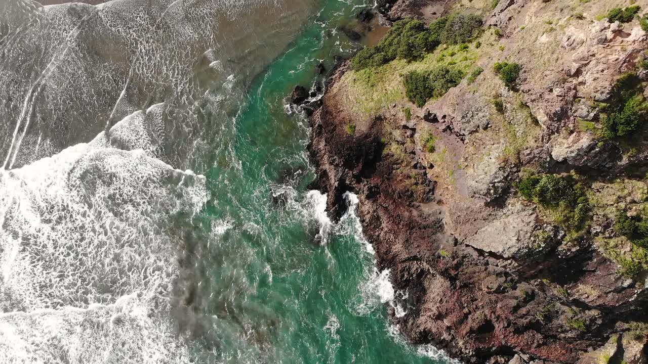 Aallot iskeytyvät ikonista Lion Rockia vasten Piha Beachilla, Länsi-Aucklandissa.