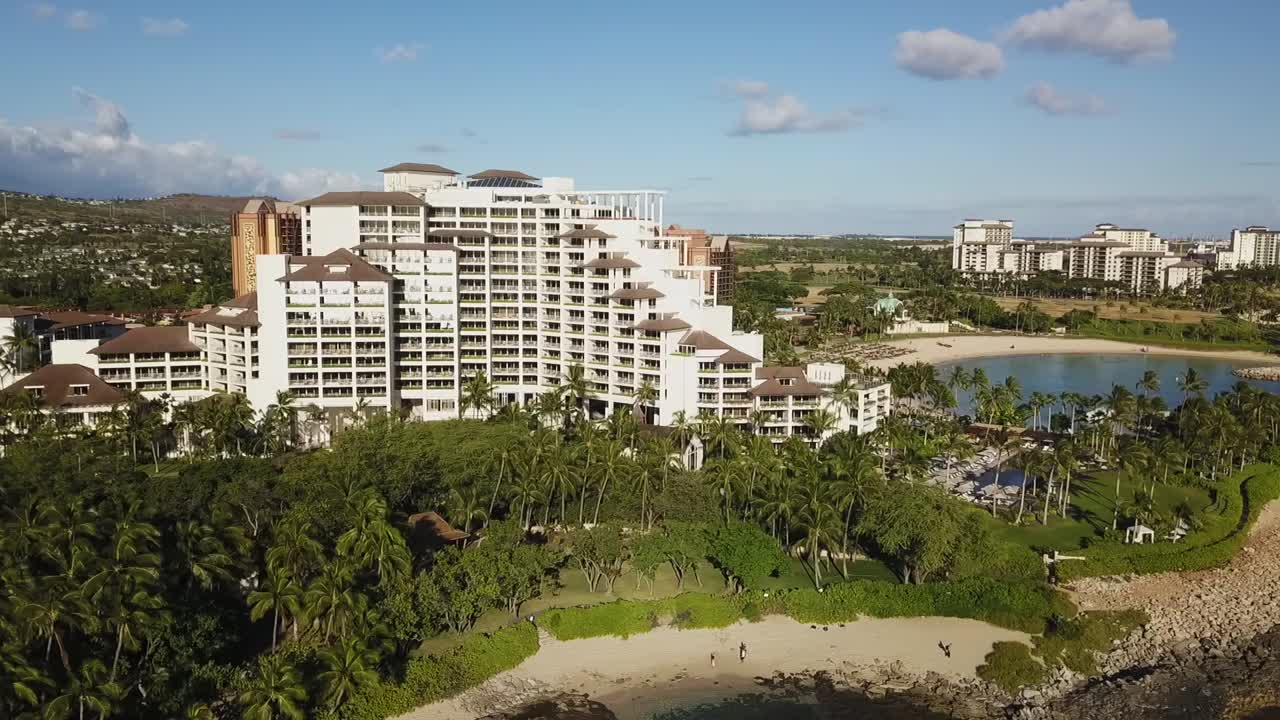 HD drone footage showcasing a smooth orbiting shot around the luxurious Four Seasons Resort in Oahu, Hawaii. Capturing the stunning beachfront, lush landscape, and elegant architecture from above.