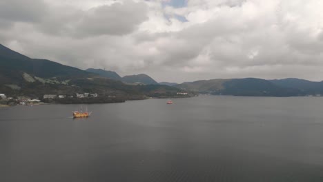 Slow-right-aerial-drone-pan-over-Lake-Ashi-in-Hakone-with-famous-orange-Pirate-Ship