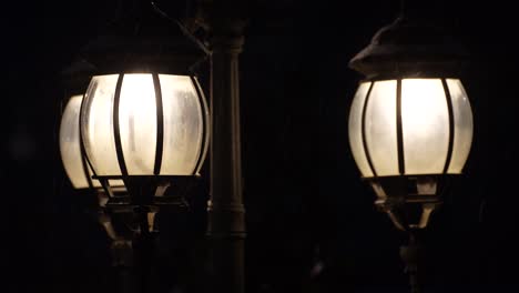 lamps of street lights on snowy evening, vintage streetlamps on dark night background, retro copy space