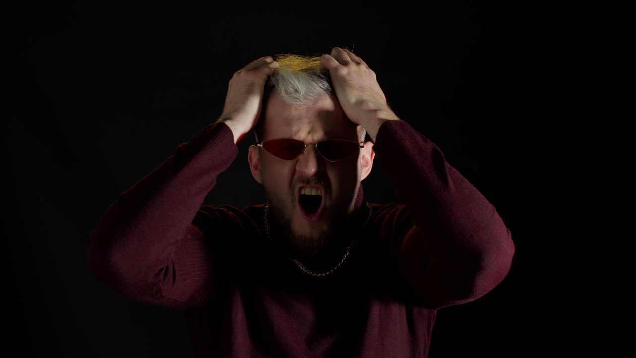 미치광이, 불행한 젊은, 공격적인 남자가 카메라를 향해 비명을 지르며,  문제와 파산으로 좌절했습니다.