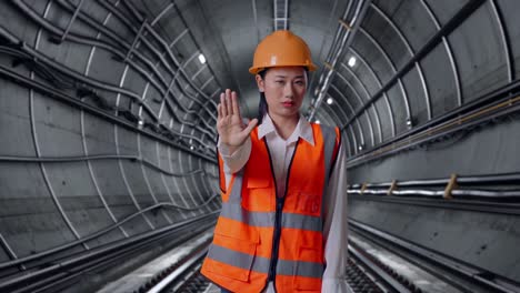 Construction worker in tunnel giving stop sign