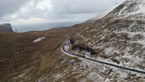 islas feroe, 4k seguimiento aéreo lento del coche mientras conduce a través de hermosas montañas y el océano en el fondo