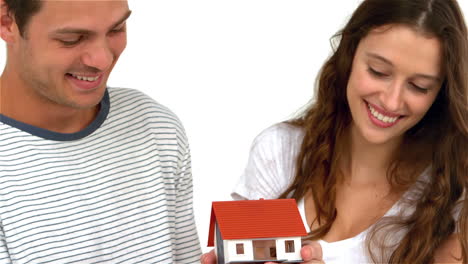 happy couple holding miniature house