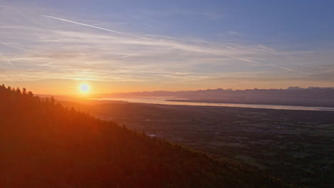 aerial sunrise over lake geneva with fiery orange and red skies, panoramic alpine views, and tranquil morning reflections on lac léman from the jura.