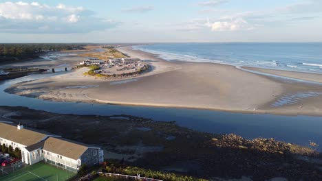 Vista-Aérea-De-La-Ciudad-Turística-De-Playa-Ogunquit-En-Maine,-EE.UU.,-La-Costa-De-Drones-Gira-Alrededor-Del-Edificio-Del-Hotel-Frente-Al-Mar-Y-La-Playa-De-Arena