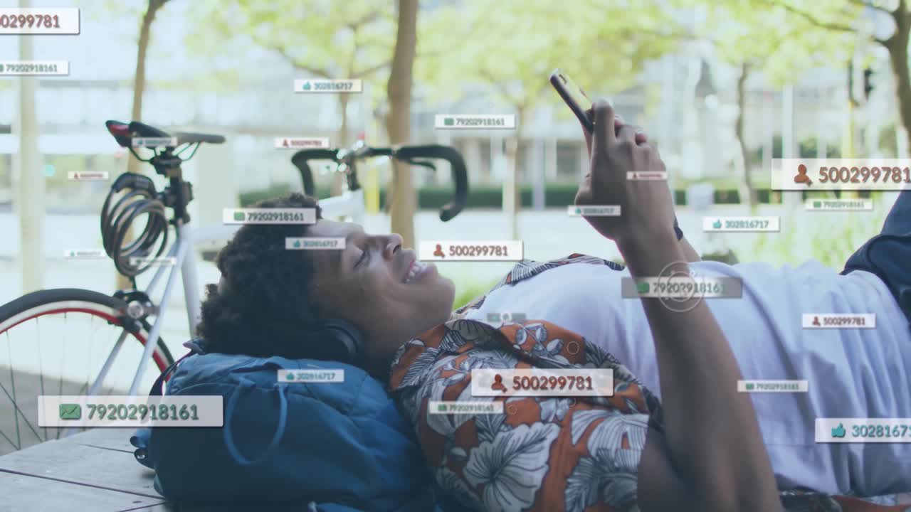 animación de iconos y números de redes sociales sobre un hombre sonriente que usa un teléfono inteligente