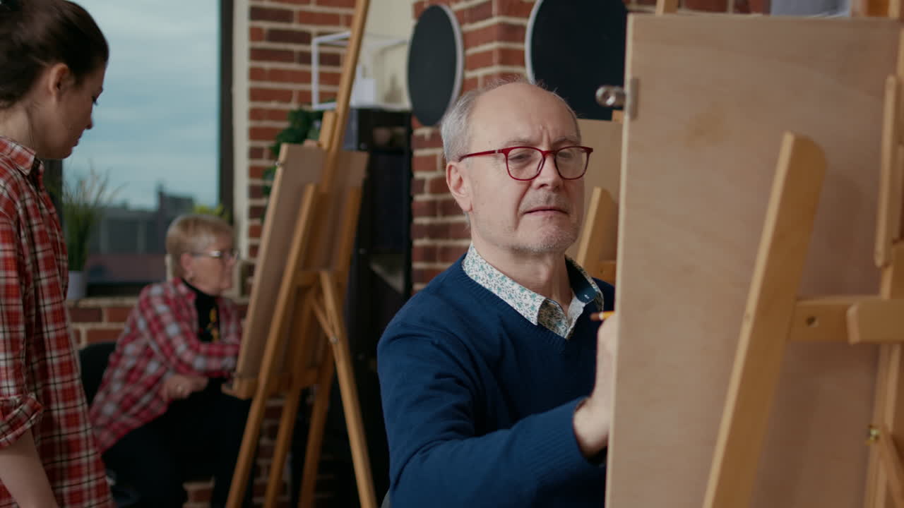 Portrait of senior man learning to draw sketch on canvas