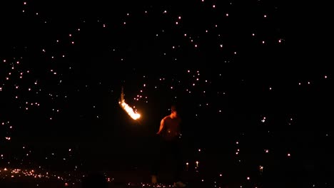 performer displays fire skills on a beach