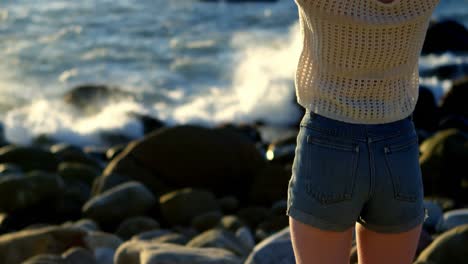 Woman-standing-with-hands-on-hair-near-seaside-4k