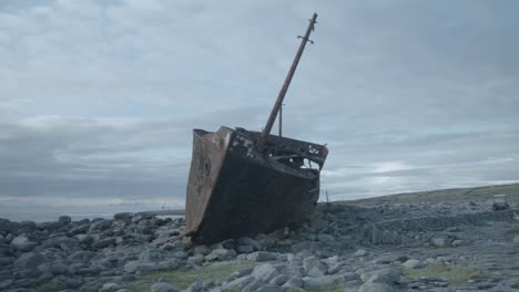 shipwreck dilapidated on rocky shoreline, front shot