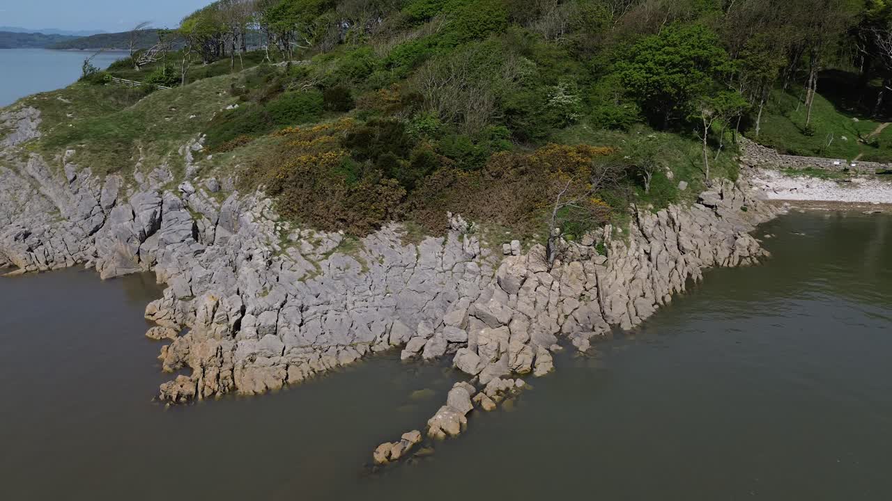 Aerial view overlooking weathered coastal erosion with lush rugged wilderness rocky slope