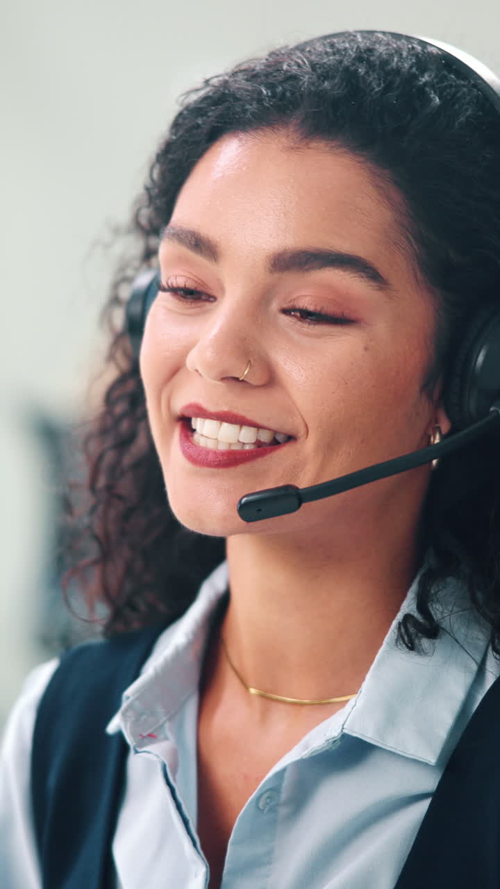 Smilende kvinne snakker i headset på et callsenter
