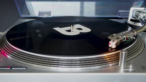 close up, modern turntable with rotating vinyl record, dj gear, equipment, b-side played