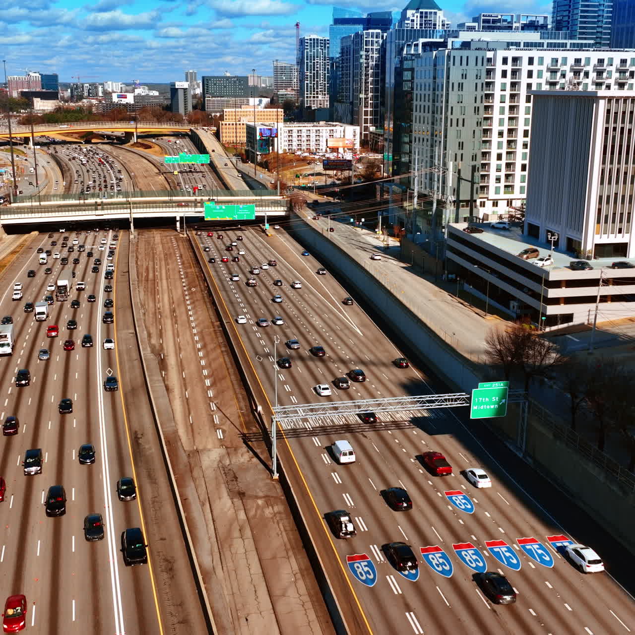 Multiple vehicles moving by the wide roads of Atlanta, Georgia, USA. Top view on city downtown on sunny daytime.