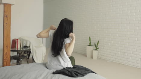 깨어나고, 스트레칭하고, 옷을 입고, 집에서 침대에서 일어나는 젊은 여성
