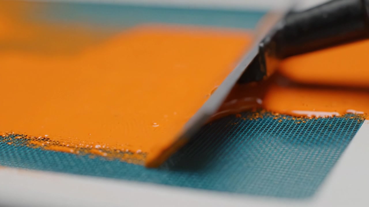 Applicazione di Vernice Arancione Vivace su Superficie Strutturata Usando una Spatola per un Effetto Artistico e una Finitura Liscia in un Processo Creativo