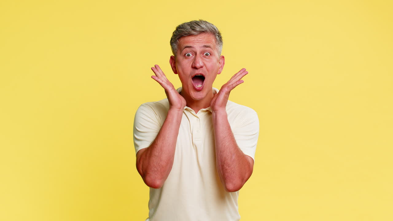 Adult man shocked with hands on cheeks mouth open in disbelief showing wow emotion strong surprise