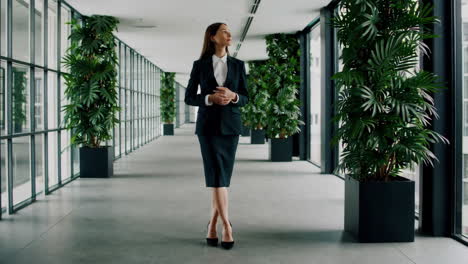 confident businesswoman walking in modern office hallway