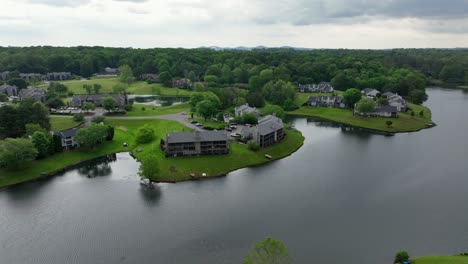 modern apartment buildings and villas with lake access in green suburb of american town. aerial approaching wilde shot. cloudy day in virginia, united states.