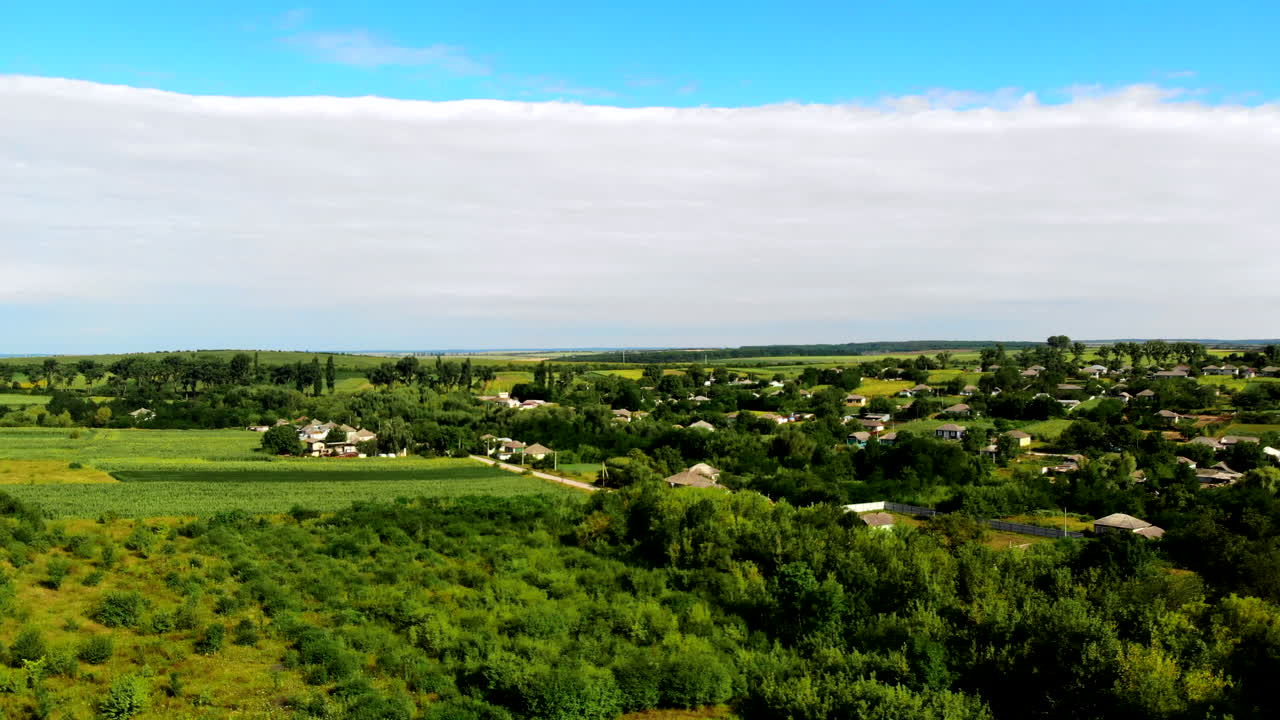 Aerial drone shot of Donduseni city with multiple residential buildings and greenery and fields in Moldova