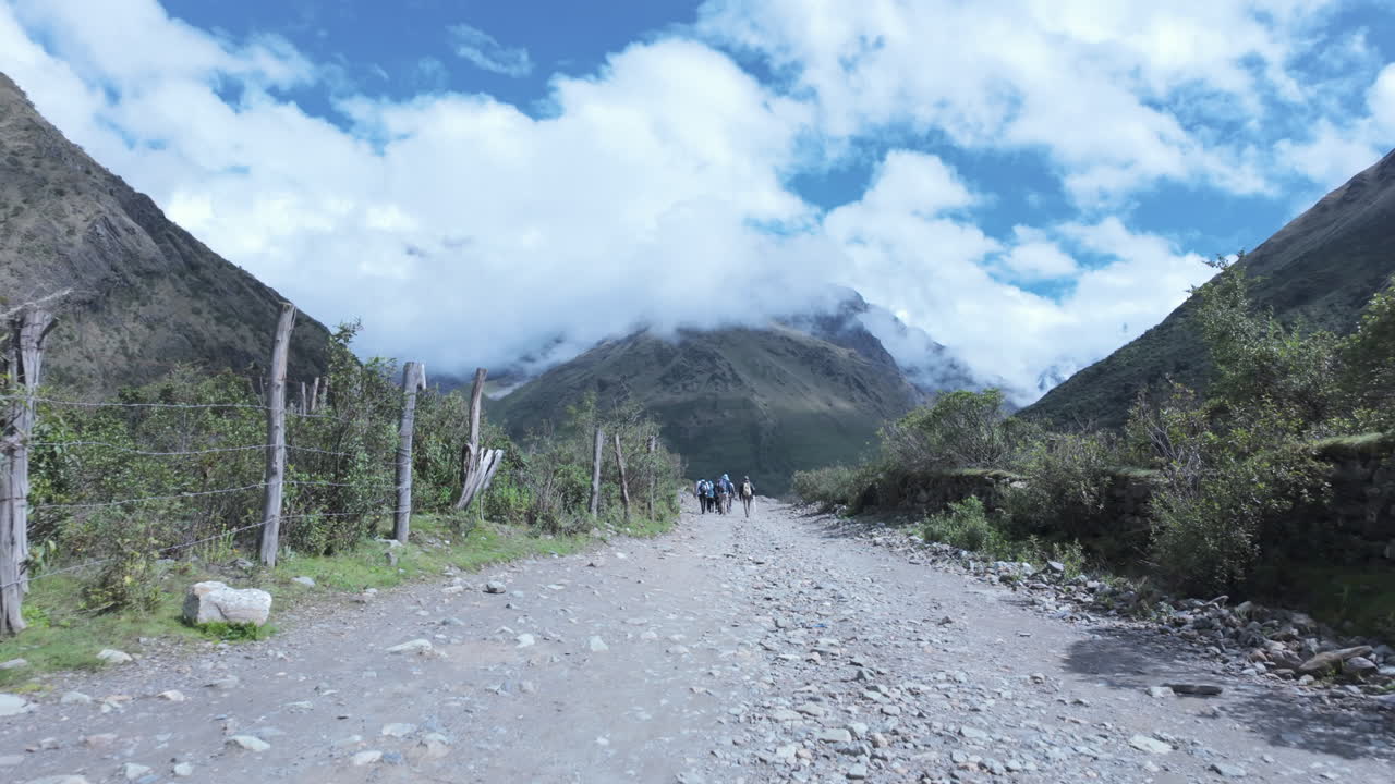 Hikers walking mountain trail toward Humantay peak and turquoise lake