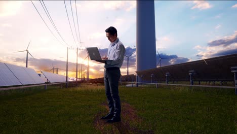 full body side view of an asian male professional worker standing with his laptop with solar panel and wind turbines, typing on his laptop's keybaord with meditation