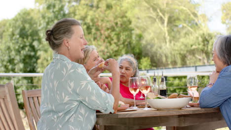 senior women enjoy a meal outdoors