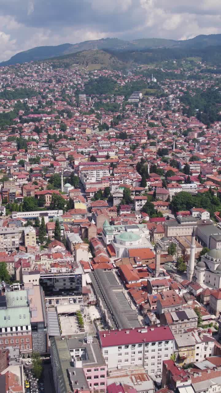 Aerial view of Sarajevo, Bosnia and Herzegovina, capturing the blend of modern and traditional architecture, red rooftops, and urban density. Vertical Video