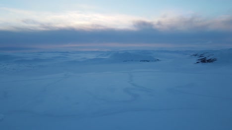 slowly panning drone footage of frozen lake at sunset in southern norway