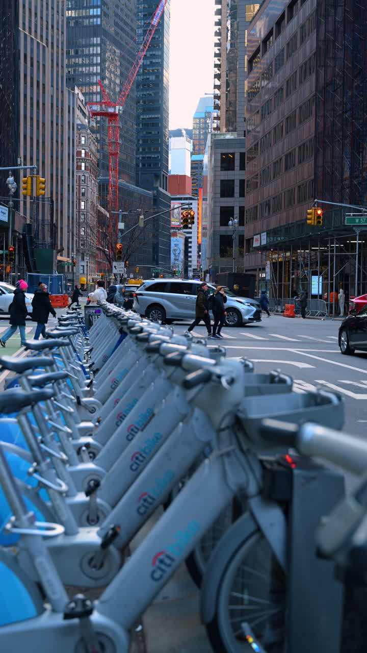 New York, USA, 2 marzo 2026: Traffico urbano e biciclette a noleggio a Midtown Manhattan, New York City. Scena di strada con stazione Citi Bike, camion commerciale e pedoni che attraversano l'incrocio.