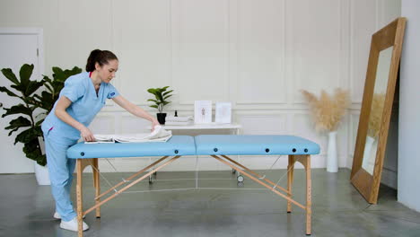 physiotherapist preparing the massage bed