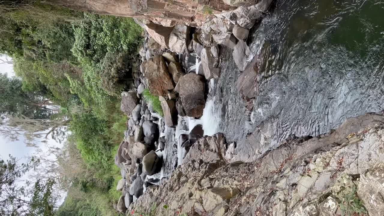 agua del lago corriendo sobre las rocas en el medio del bosque