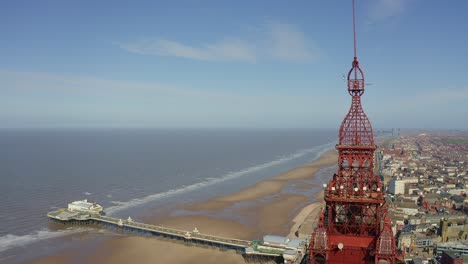 Stunning-aerial-footage,-view-of-Blackpool-Tower-by-the-award-winning-Blackpool-beach,-A-very-popular-seaside-tourist-location-in-England-,-United-Kingdom,-UK