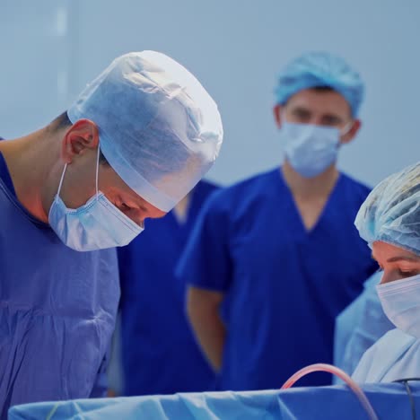 surgery in operating theater. doctors in blue medical uniform conduct an operation. group of young doctors observe the surgical process in clinic.