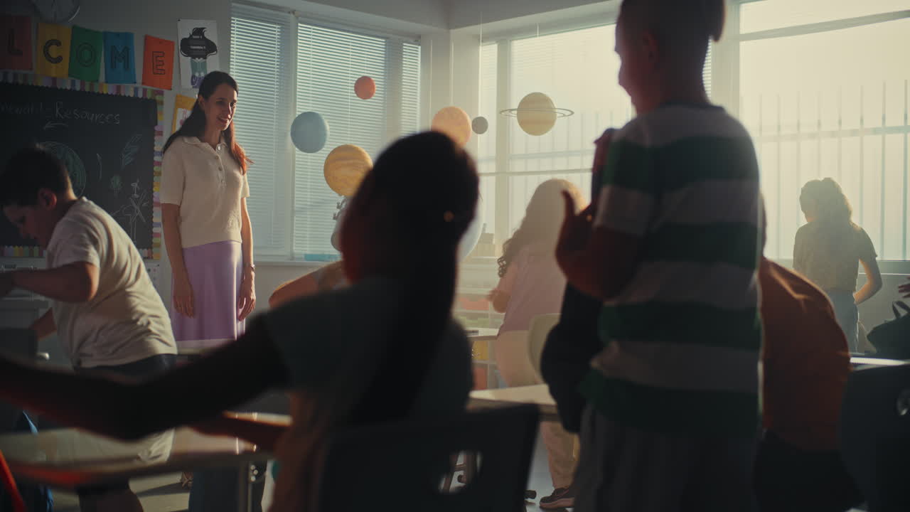 Female teacher greeting young boys and girls at th 2025 07 31 02 03 07 utc.mov | back to school, backpack, beginning, boy