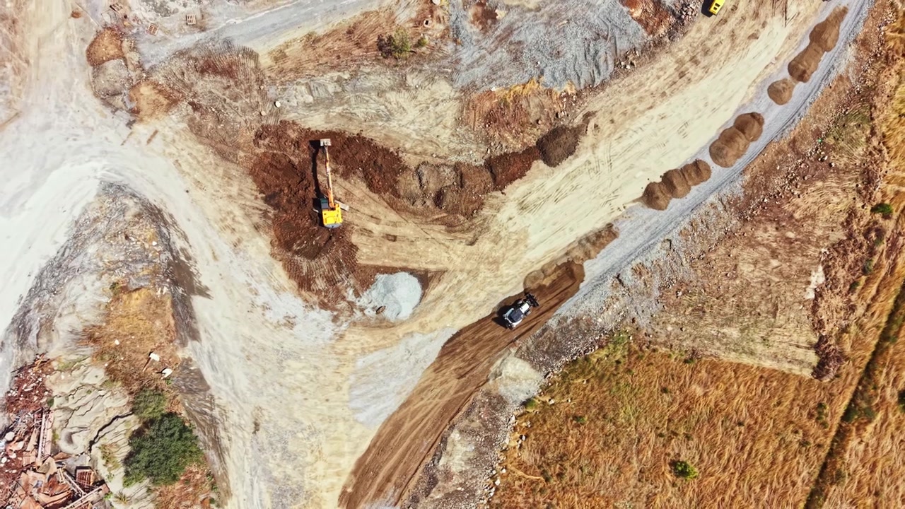 Granite quarry operation with heavy machinery working on site during daylight hours