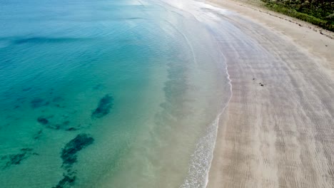 Drone-Aéreo-Siguiendo-A-Lo-Largo-De-La-Costa-De-La-Impresionante-Bahía-De-Maitai,-Península-De-Karikari,-Northland,-Nueva-Zelanda-Aotearoa