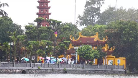 people exploring tran quoc pagoda in the rain