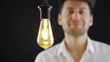 un hombre inteligente tiene una idea y toca una lámpara simbólica y la enciende.