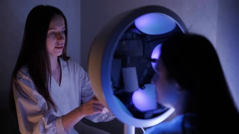 cosmetólogo realizando un examen facial bajo una lámpara