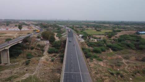cinematic aerial shot of highway bridge built over dry river basin in drought conditions in the summer heat due to global warming and climate change, india