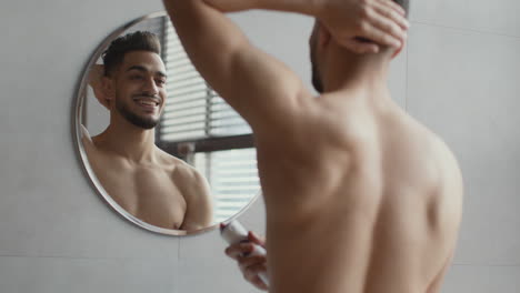man applying deodorant in bathroom