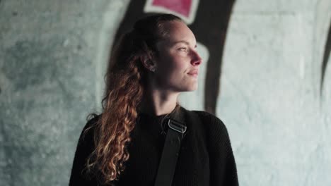 Natural-girl-in-front-of-graffiti-wall-looking-around-in-copenhagen