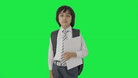 niño de escuela indio confiado de pie con libros pantalla verde