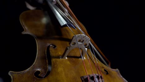 cellist playing legato notes in slow motion. close up of bow and fingers.
