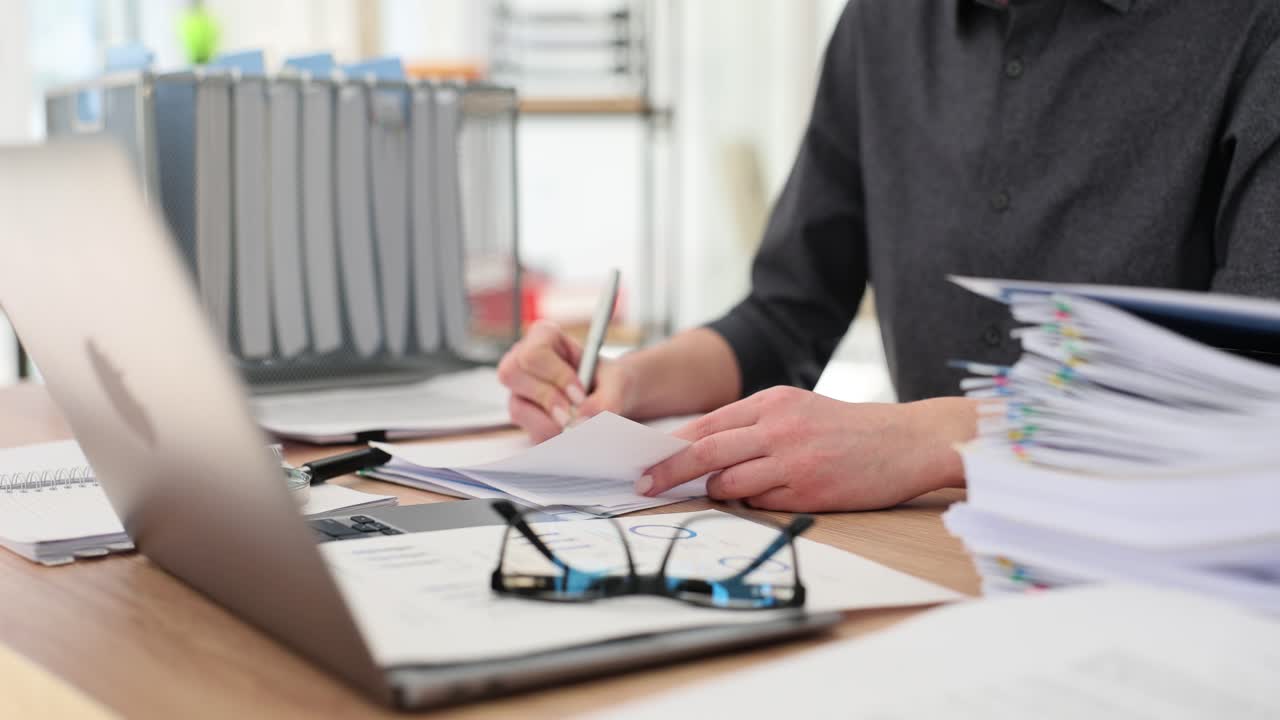Eine Managerin füllt am Arbeitsplatz Arbeitsunterlagen aus.
