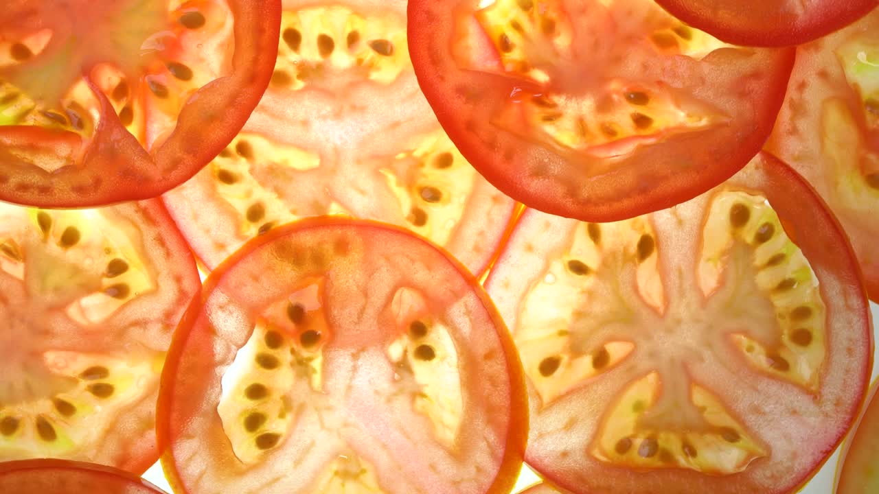 색 배경에 토마토 조각을 회전시키고, 빛 배경에 새로 잘라진 토마토를 가까이 돌려 서서히 회전시니다.